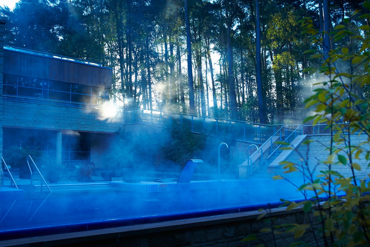 Steaming Outdoor Pool surrounded by the wintery forest.